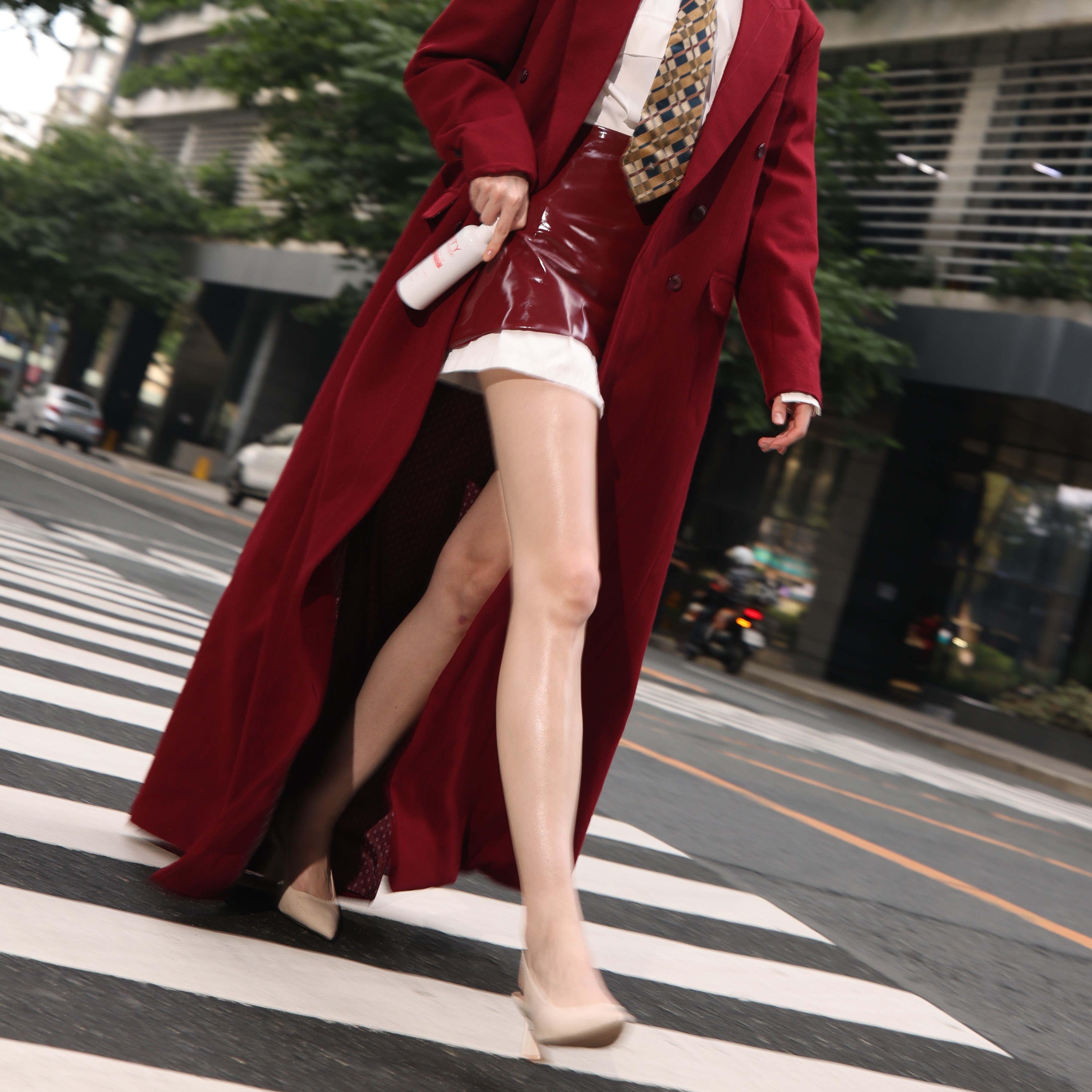 Woman carrying BTY Advance lotion for varicose veins, crossing street