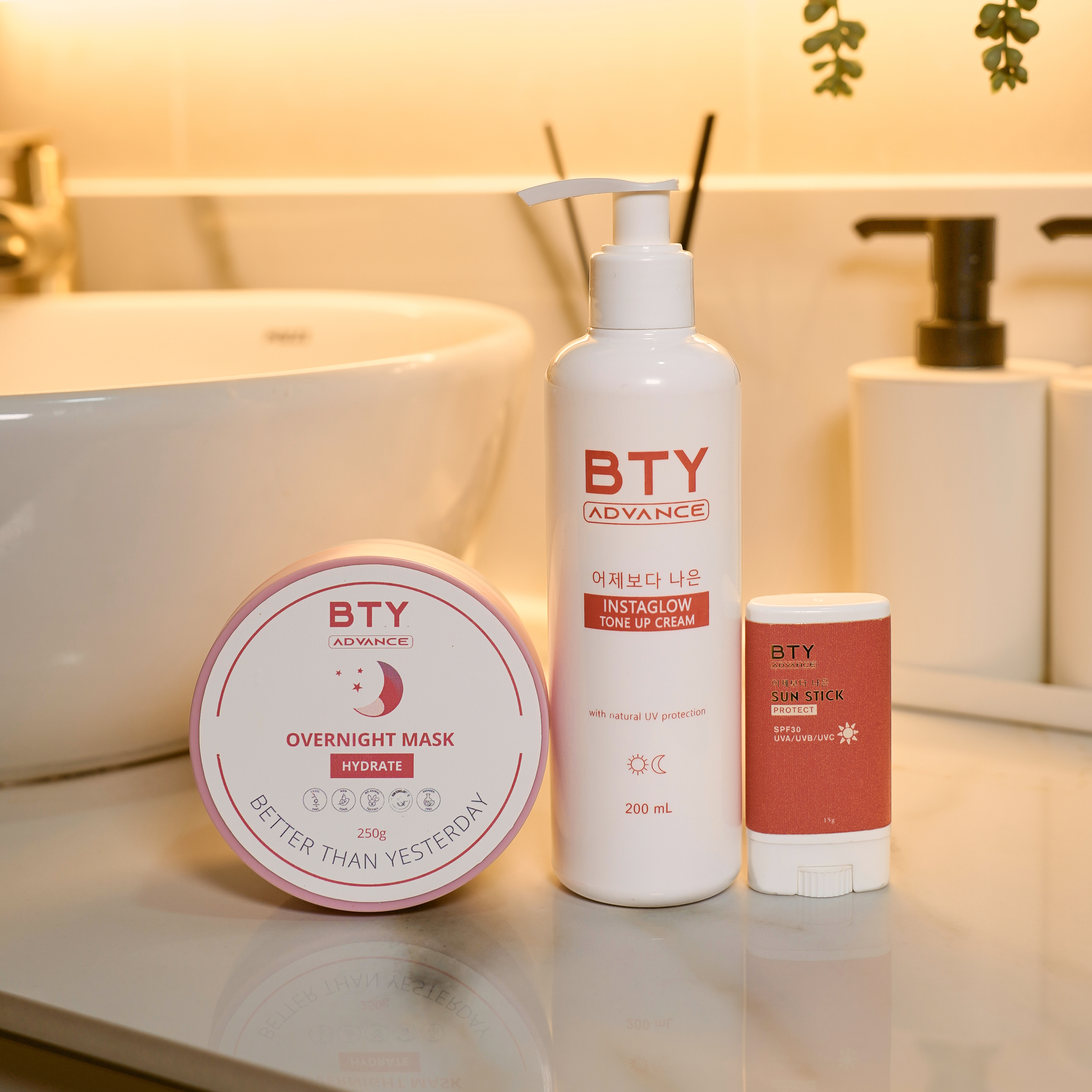 BTY Advance Overnight Mask, Instaglow, and Sun Stick by a sink