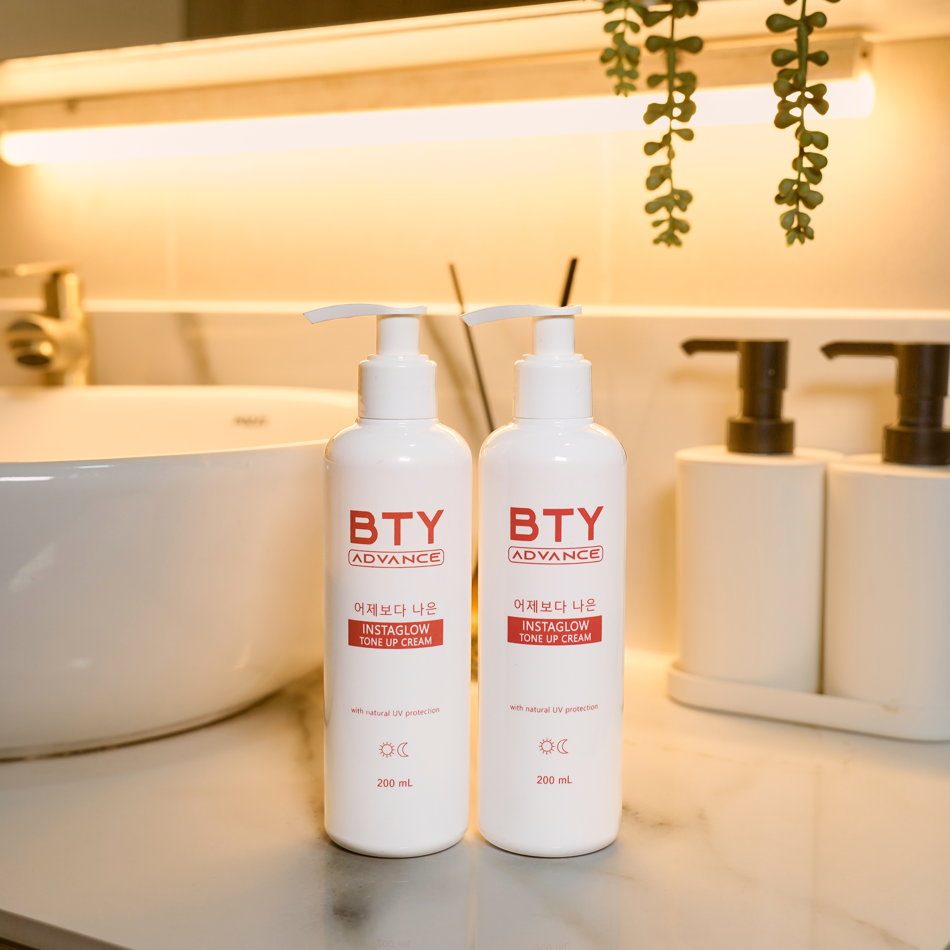 Twin BTY Advance Instaglow Tone-Up Cream bottles beside a bathroom sink
